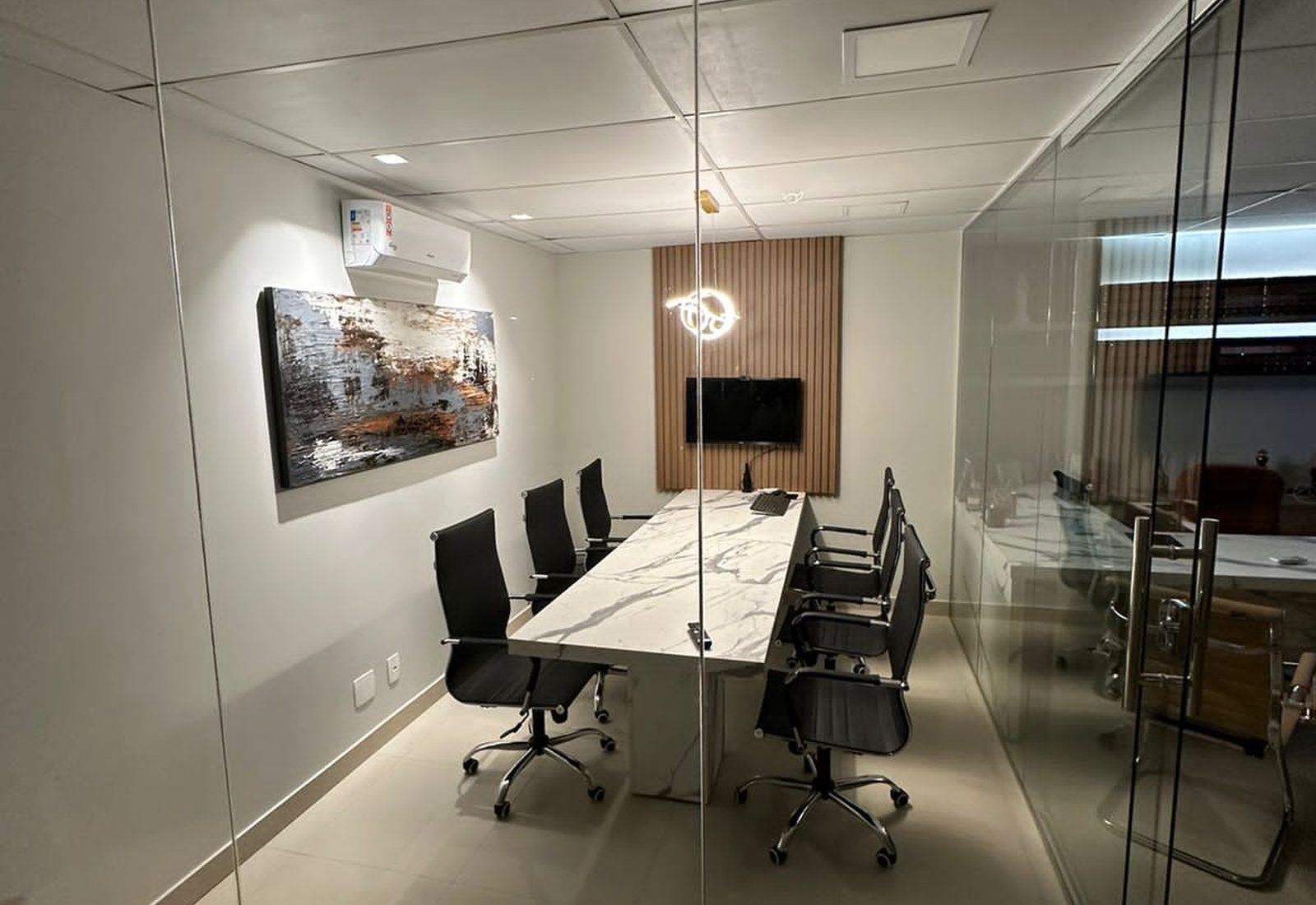 Sala de reunião envidraçada do escritório, vista de dentro, com mesa longa e cadeiras